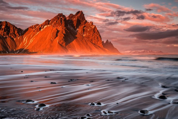 Sunset at Stokksnes by Sophie Carr. Car says of this piece: "Water trails on the beach at Stokksnes at sunset, with Vesturhorn illuminated by the setting sun." Photo taken in Iceland. Click here for more of the photographer’s work!